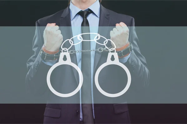 Man in a business suit with chained hands. handcuffs for sex games. concept of erotic entertainment.