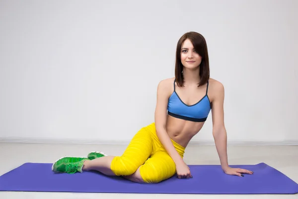 Happy cutie athletic girl ,  execute exercise on muscles belly  and smile