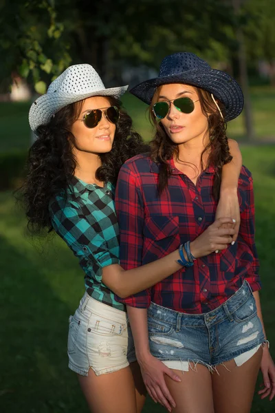 Sexy girl in cowboy hats and plaid shirts. sunglasses