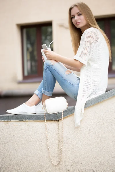 Stylish woman drinking coffee to go in a city street