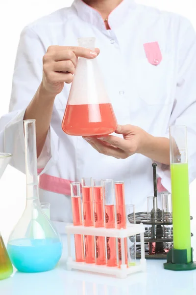 Hands holding test tubes with chemical elements.