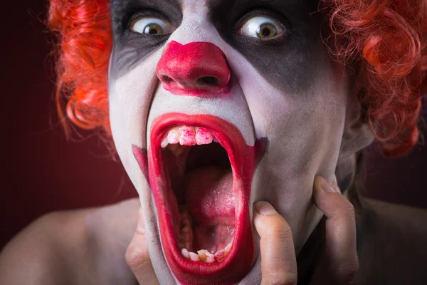 Evil Spooky Clown Portrait on dark background. expressive man