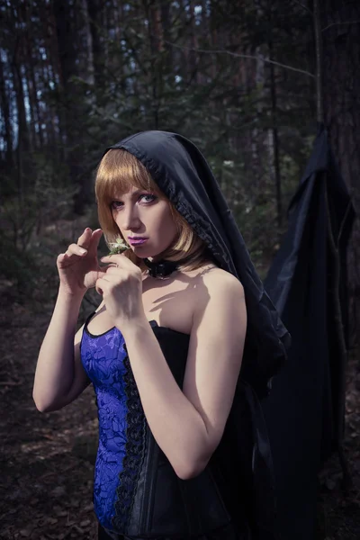 Dark portrait of the forest keeper. Fantasy and gothic. witch in woods, conjures flower