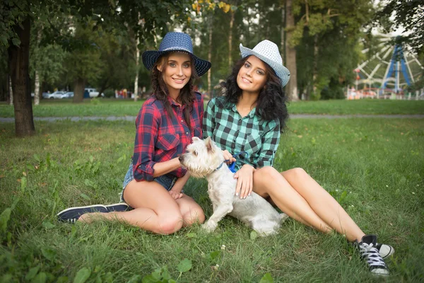 Two girls walking with his dog. cowboy hat and plaid shirt