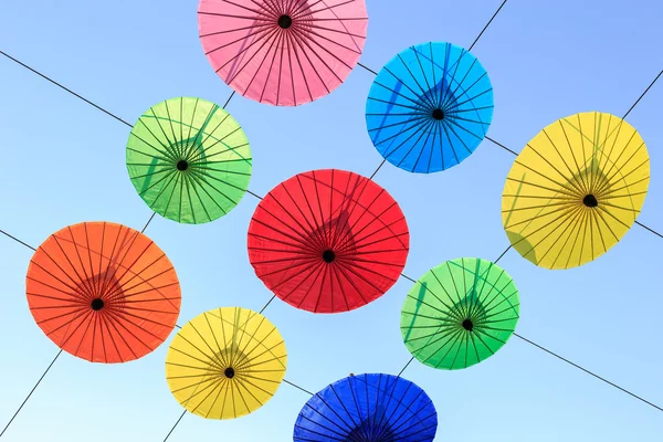 Colorful umbrella hang on electric cable and sky background