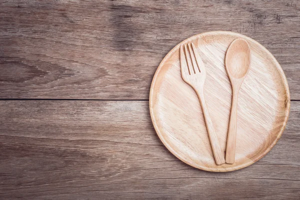 Wooden dish and spoon on wooden table top view