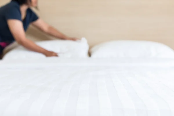 Blur woman set up white bed sheet in hotel room