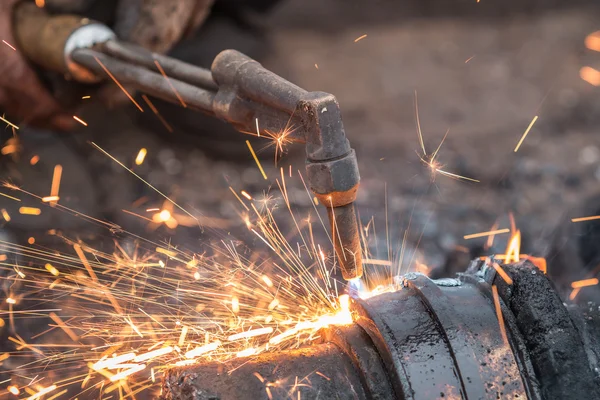 Worker cutting steel using metal torch
