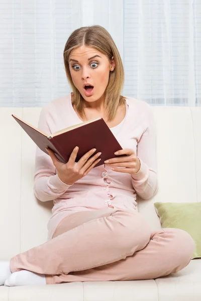 Surprised woman is reading book
