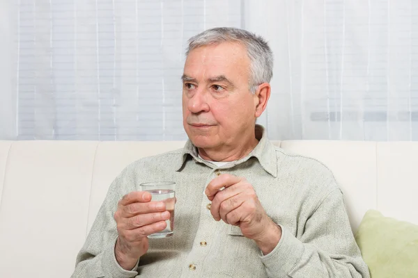 Old man taking pill