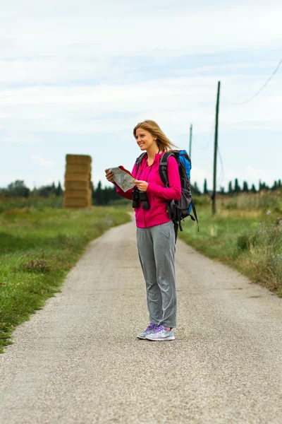 Woman with backpack is holding a map