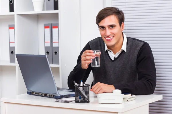 Business sitting in his office,working and drinking water