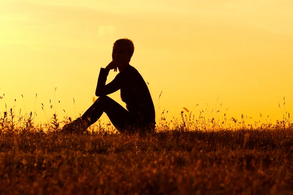 A silhouette of a woman sitting