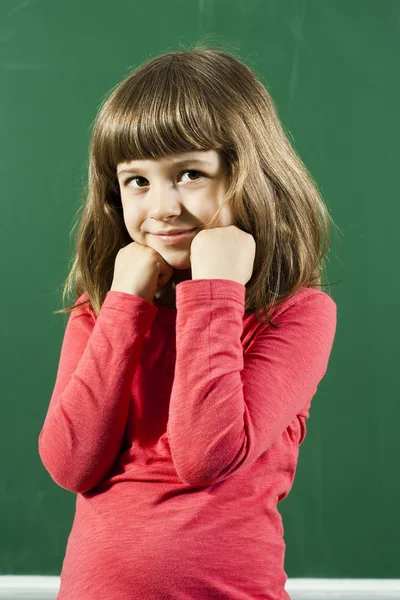 Girl is thinking in front of blackboard