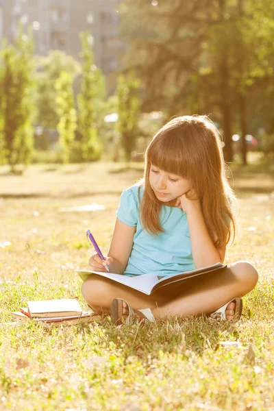Little girl studying in park
