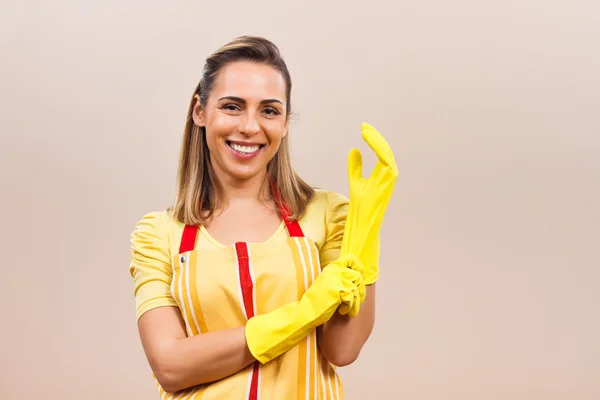Young housewife putting rubber gloves on
