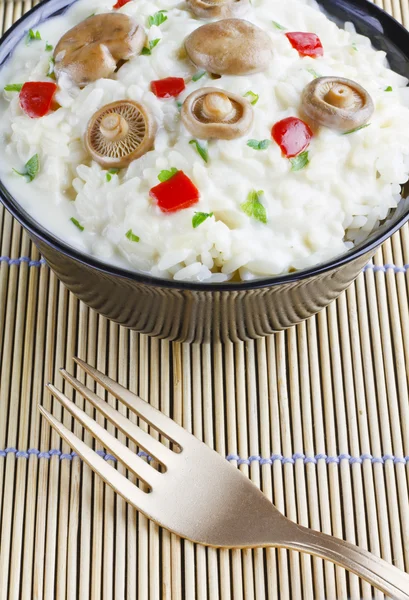 Saffron Milk Cap mushroom rice on a bowl on a bamboo mat