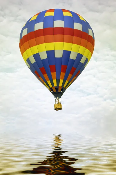 Colorful hot air balloon reflecting in water