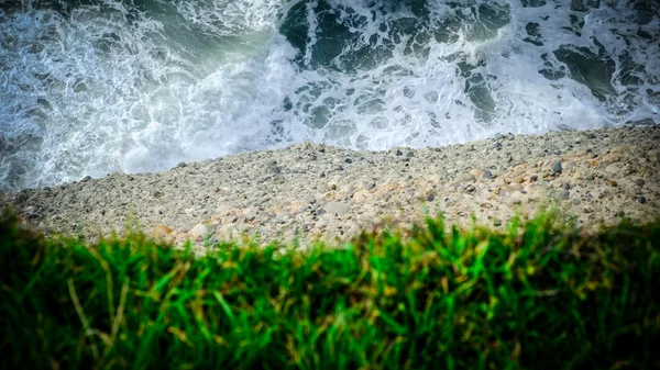 Water, earth and grass. closeup of a cliff