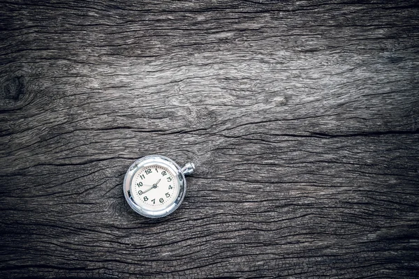 Pocket watch on old wooden background.