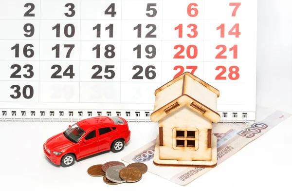House, car and money on a background calendar. Payment of tax pa