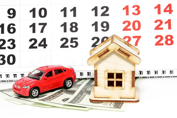 House, car and money on a background calendar. Purchase of prope