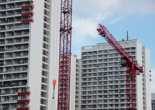 Red crane at construction site with building development