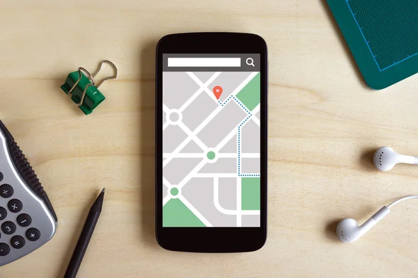 Map gps navigation application on smart phone screen on wooden d