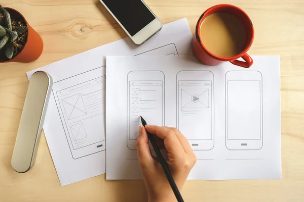 Designer drawing mobile application wireframe