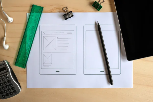 Designer desk with paper prototype of a tablet application