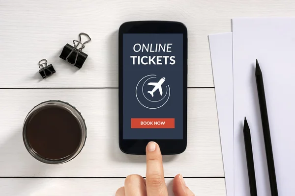 Online tickets concept on smart phone screen with office objects