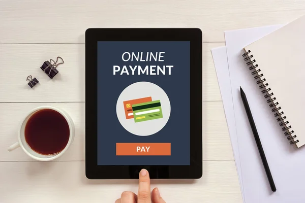 Online payment concept on tablet screen with office objects