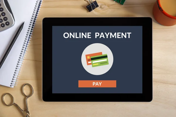 Online payment concept on tablet screen with office objects