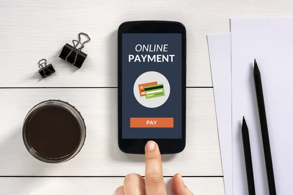 Online payment concept on smart phone screen with office objects