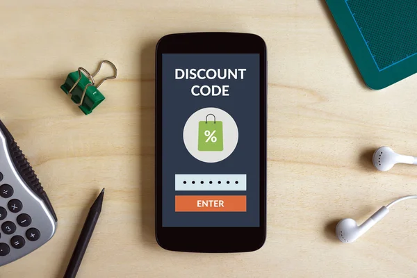 Discount code concept on smart phone screen on wooden desk