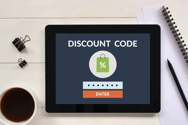 Discount code concept on tablet screen with office objects