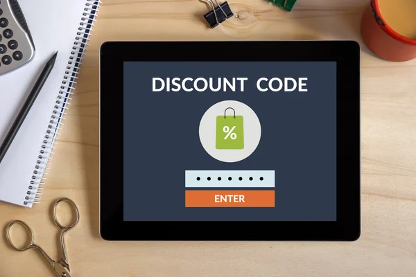 Discount code concept on tablet screen with office objects