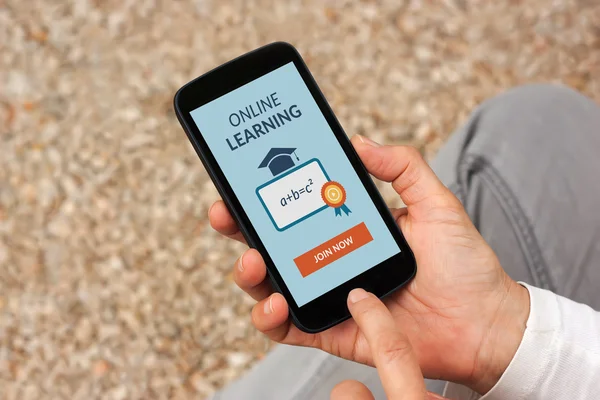 Hands holding smart phone with online learning concept on screen