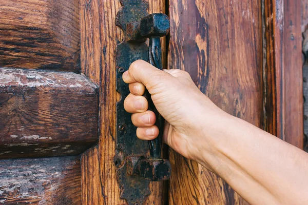 Wooden door with a hand on handle