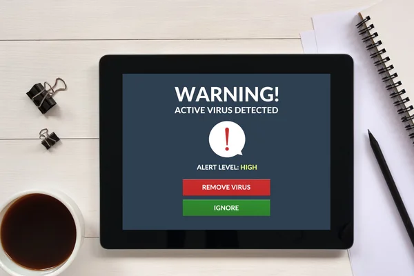 Virus alert on tablet screen with office objects