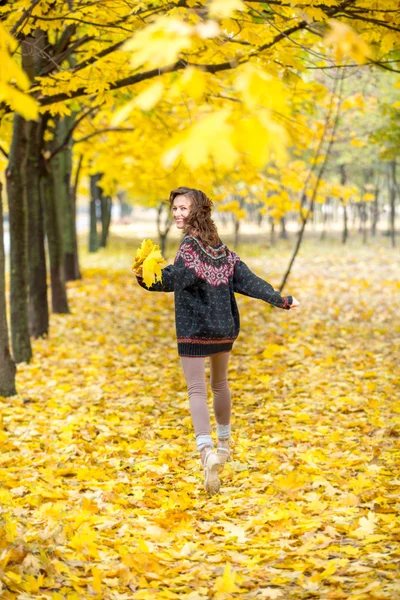 Autumn woman in park in knitted autumn clothes