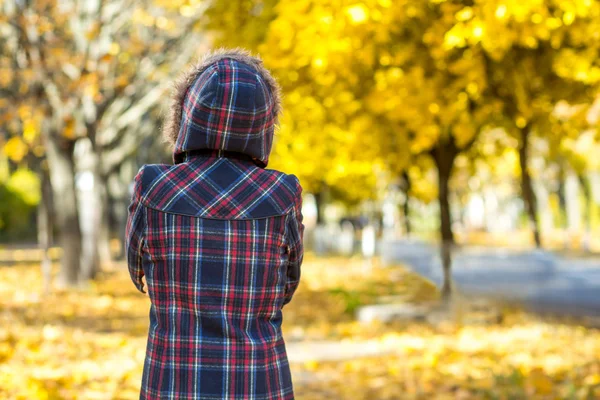 Sad woman outdoors in autumn scenery