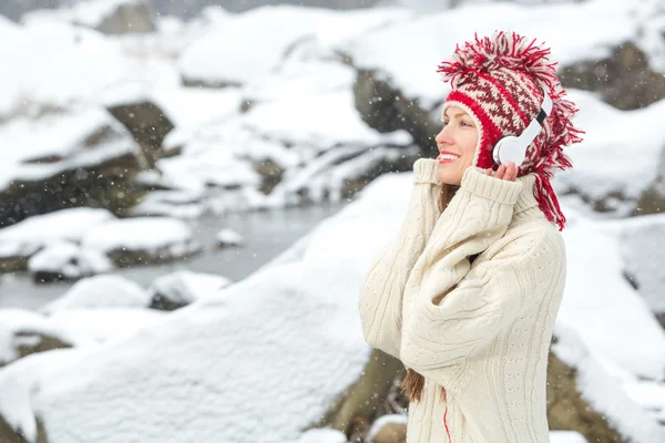 Girl listening to music in winter landscape