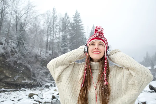 Girl listening to music in winter landscape