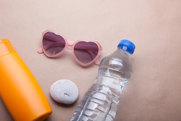 Suntan lotion glasses and bottle of water