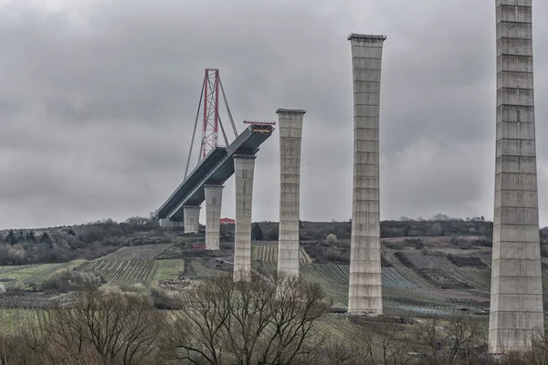 Bridge construction site under a dramatic sky.