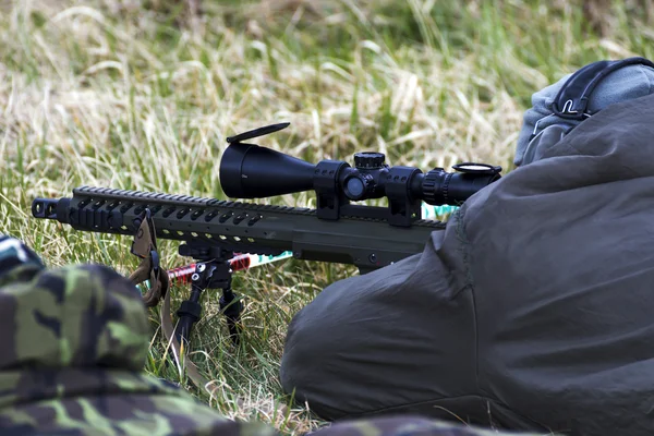 Military sniper aims at a target