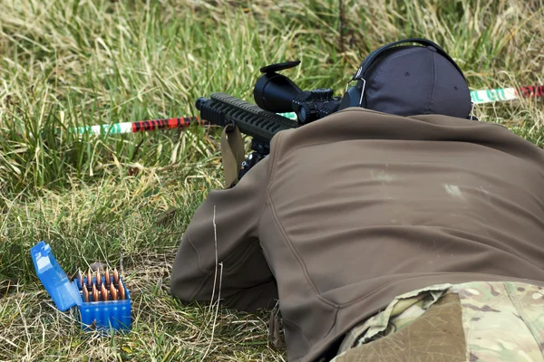 Military sniper aims at a target