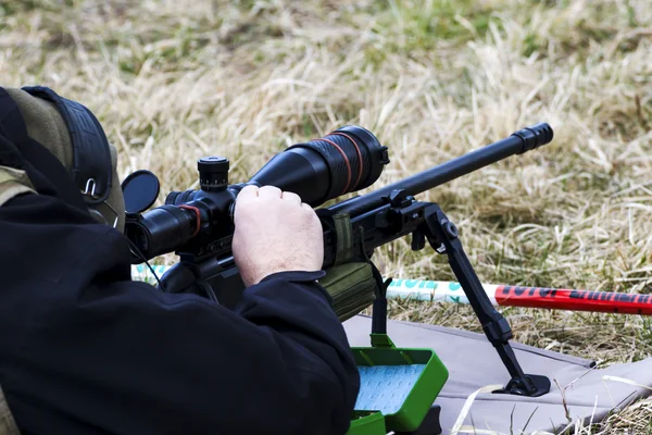 Military sniper aims at a target