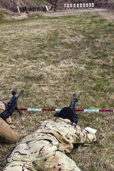 Military sniper aims at a target